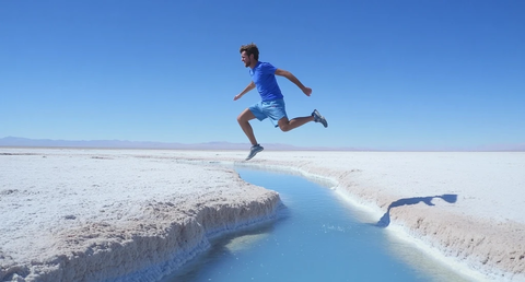 男子跳过小溪盐漠景象