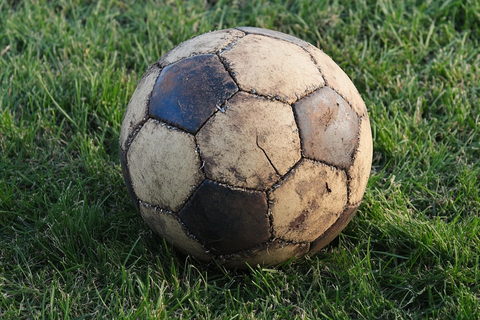 磨损足球静躺草地