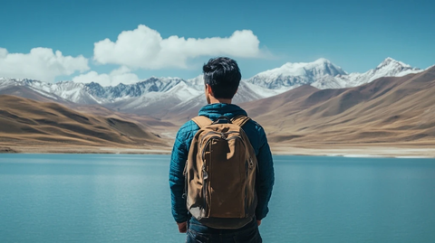 男子背包站立湖边看山