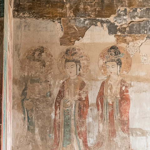 斑驳壁画上的三位古代人物形象