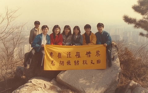 众人在山上举着横幅的合影