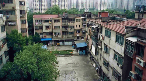 老旧居民区鸟瞰图周围环绕高楼大厦